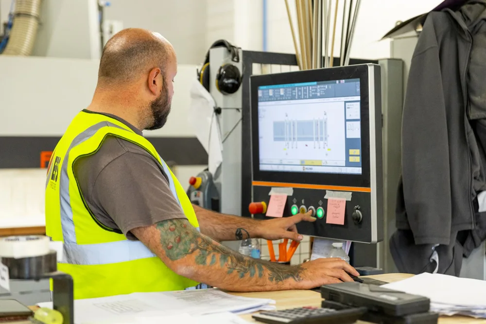 EFS technician operating precision machinery at a manufacturing control screen